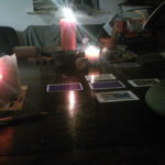 a tarot spread in a dark room with candles all around