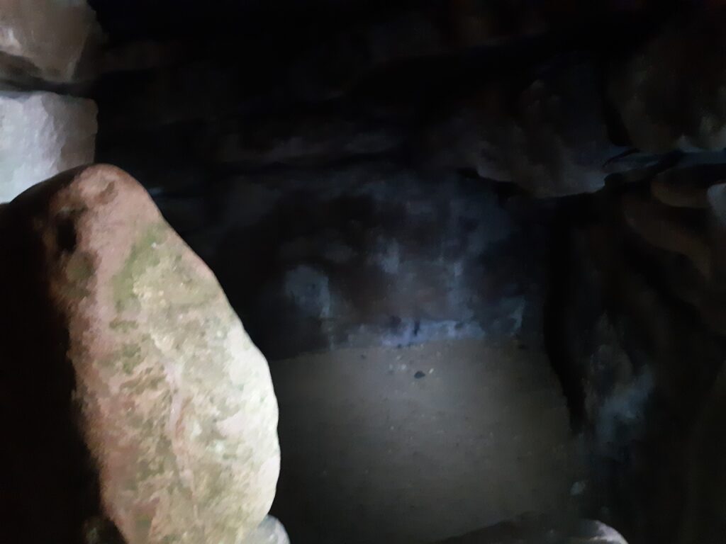 a torchlit shot of a chamber inside the barrow