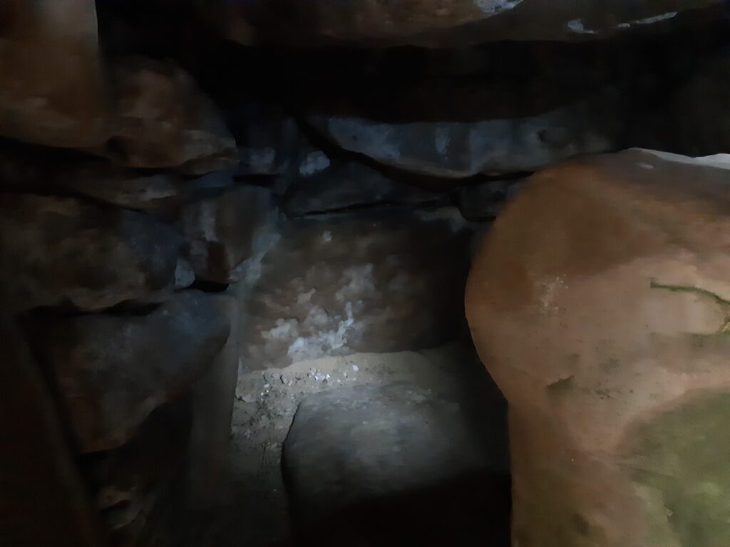 a torchlit shot of a rocky tomb chamber